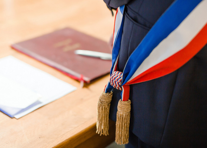 Maire avec son écharpe tricolore avec documents officiels
