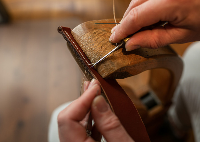 Femme en train de coudre une ceinture en cuir